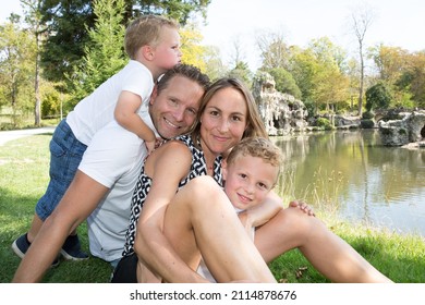outdoor portrait play near river lake outdoor park happy family Mother father and children son