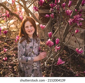 Outdoor Portrait Of Preadolescent Girl Among Blooming Flowers