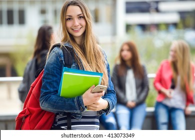 Outdoor portrait of pretty student girl in the street after class.