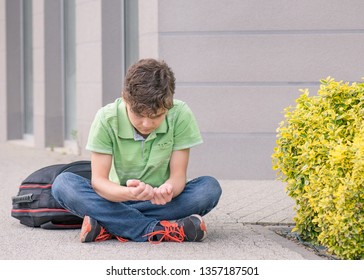 Outdoor Portrait Of Sad Teen Boy 14 Years Old With Backpack On The First Or Last School Day. Back To School After Vacation.