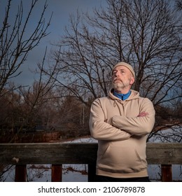 Outdoor Portrait Of A Senior Man In A Sweatshirt Starring At Winter Night Sky In His Backyard