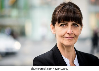 Outdoor Portrait Of Smiling Confident Senior Business Woman Looking Away