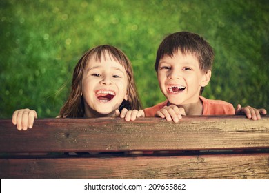 Outdoor portrait of smiling girl and boy who lost his milk teeth - Powered by Shutterstock