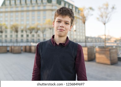 Outdoor Portrait Of Smiling Teenager Boy 14, 15 Years Old. City Background, Golden Hour