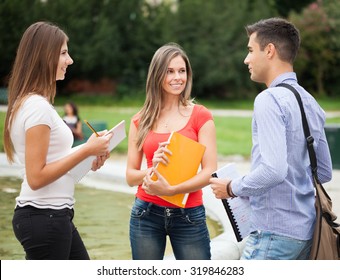 Outdoor Portrait Of Three Students Talking In A Park