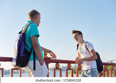 Outdoor Portrait Of Two Friends Teenagers Boys 15, 16 Years Old, Laughing, Talking In Sunny Day, Standing On Bridge Over The River. Urban Lifestyle, Teens, Friendship, Communication