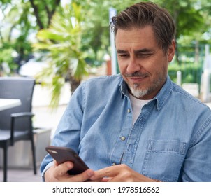 Outdoor Portrait Of White Man Using Phone On A Terrace, Checking E-mails, Reading News Feed, Posting On Social Media.