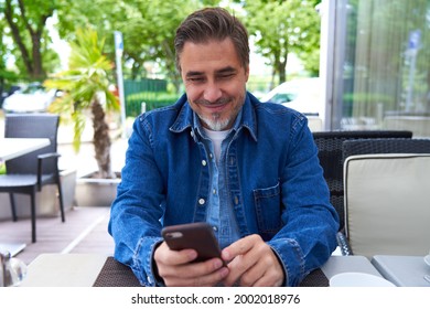 Outdoor Portrait Of White Man Using Phone On A Terrace, Checking E-mails, Reading News Feed, Posting On Social Media.