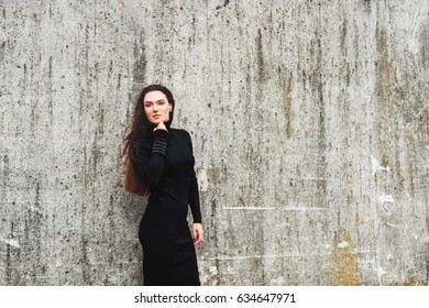 Outdoor Portrait Of Young 35 Year Old Woman With Long Dark Hair, Wearing Black Turtle Neck Dress