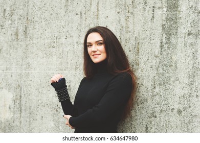 Outdoor Portrait Of Young 35 Year Old Woman With Long Dark Hair, Wearing Black Turtle Neck Dress