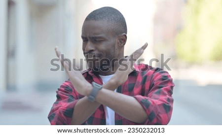 Outdoor Portrait of Young African Man Rejecting and Disliking