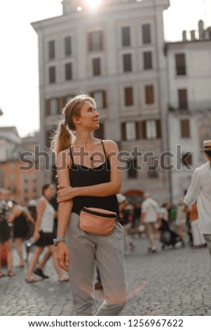 Outdoor portrait of young beautiful blonde girl posing in street of European city Italian urban ancient architecture. Fashion outdoor Europe.