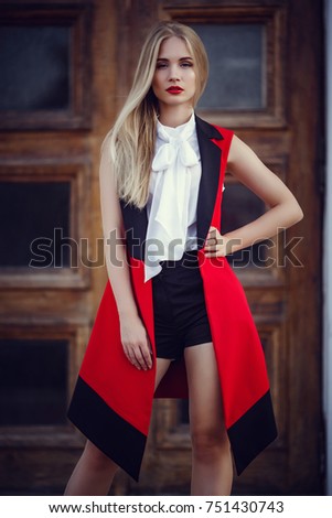 Outdoor portrait of a young beautiful fashionable lady walking on street. Model wearing stylish clothes. Girl looking aside. Female fashion. City lifestyle.
