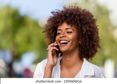 Outdoor portrait of a Young black African American young woman speaking on mobile phone - Powered by Shutterstock