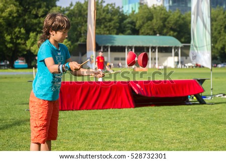 outdoor portrait of young boy playing with diabolo, chinese yo-yo toy