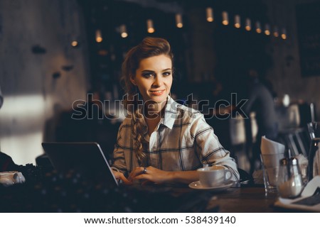 outdoor portrait of a young girl she works as a freelancer in a cafe drinking a delicious hot Cup of coffee from text send mail loads the photo instagram freelancer drinking cappuccino in sunglasses