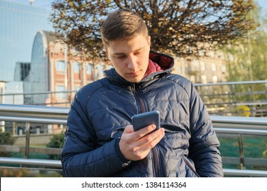 Outdoor Portrait Of Young Man 20 Years Old, Student Listening Music  