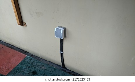 Outdoor Power Socket. Safe Electric Plug Inside Plastic Box Installed On Cement Wall