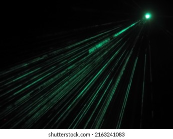 The Outdoor Projector Shines Bright Emerald Beams In The Dark. Laser Show. Blurred Image