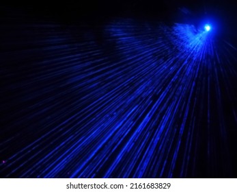 Outdoor Projector Shines Bright Neon Blue Beams In The Dark. Laser Show. Blurred Image