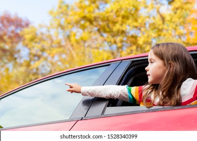 Outdoor Recreation And Awesome Adventures With Kids In Fall. Young Child Girl Looking Out Of A Car Window During A Family Trip To Nature On A Warm Autumn Day. Exploring Nature, Travel, Family Vacation