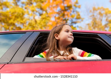 Outdoor Recreation And Awesome Adventures With Kids In Fall. Young Child Girl Looking Out Of A Car Window During A Family Trip To Nature On A Warm Autumn Day. Exploring Nature, Travel, Family Vacation