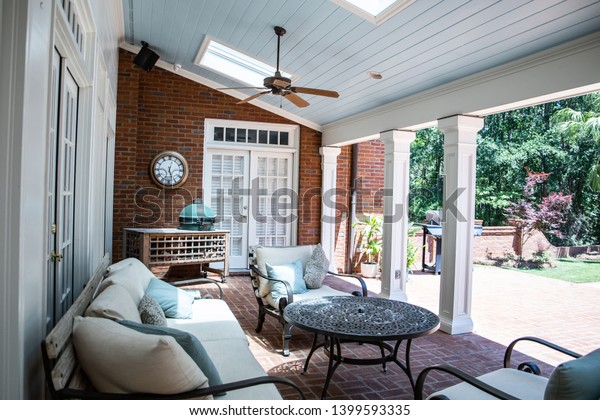 Outdoor Residential Back Patio Porch with Couches\
and Chairsand a Table