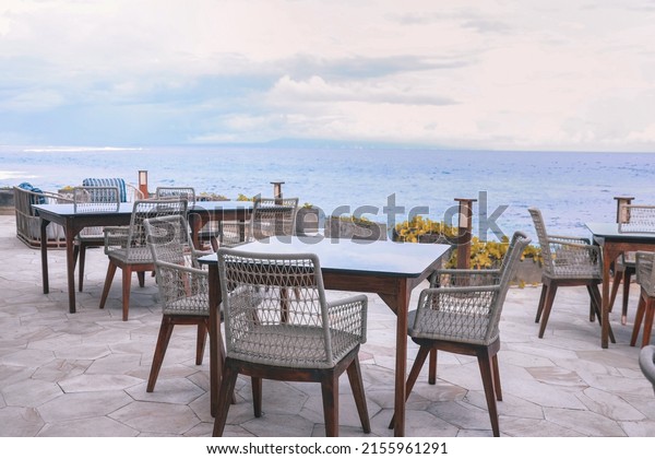 Outdoor restaurant\
at the beach. Cafe on the beach, ocean and sky. Table setting at\
tropical beach\
restaurant.