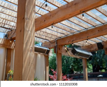 An Outdoor Restaurant Set Up With Patio And Wooden Overhang And Speakers