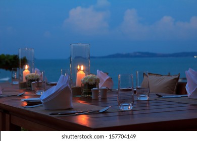 Outdoor Restaurant Table Dinner Setting On The Beach At Dusk