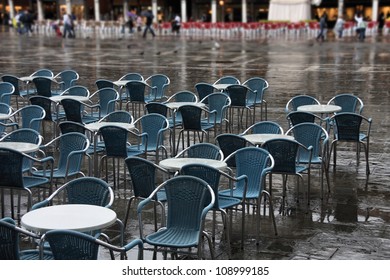 Outdoor Restaurant Tables With Yellow Chairs. Cafe Patio In Rainy Venice, Italy. Saint Mark's Square (Piazza San Marco).