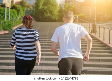 Outdoor Running Mature Couple. Man And Woman Of 40 Years Old Running Upstairs, View From The Back.