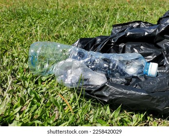 Outdoor scenery during sunny day with plastic bottles and black plastic. Concept of Earth Day. - Shutterstock ID 2258420029