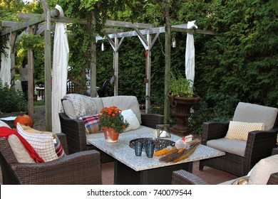 Outdoor Seating Arrangement Around A Gas Fire Pit Table In The Fall