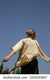 Outdoor Serie Of Imges Of Young Woman In Beige Silk Kimono Against Clear Blue Sky