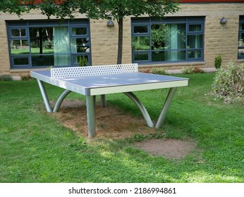 Outdoor Shiny Metal Table Tennis Structure Stood On Grass Building In Background Two Windows Single Tree Huddersfield Yorkshire England 08-05-2022 By Roy Hinchliffe