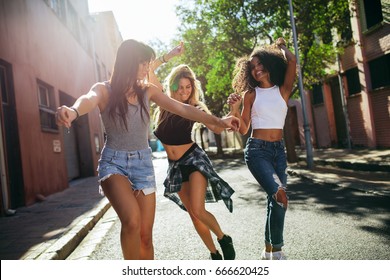 Outdoor shot of young women having fun on city street. Female friends enjoying a day around the city.