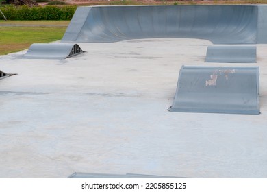 Outdoor Skatepark With Blue Sky And Grey Concrete