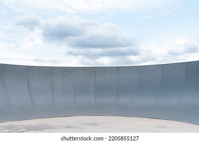 Outdoor Skatepark With Blue Sky And Grey Concrete