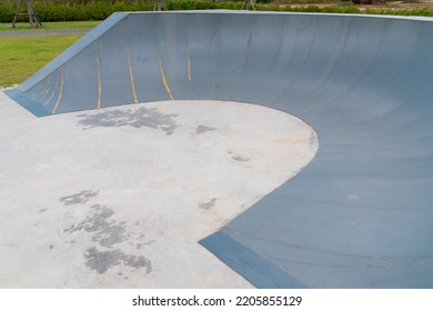 Outdoor Skatepark With Blue Sky And Grey Concrete