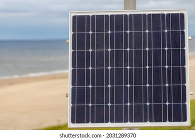 Outdoor Small Solar Cell Panel On The Pole, Photovoltaic Cell Is An Electrical Device That Converts The Energy Of Light Directly Into Electricity By The Photovoltaic Effect, Green Energy Background.