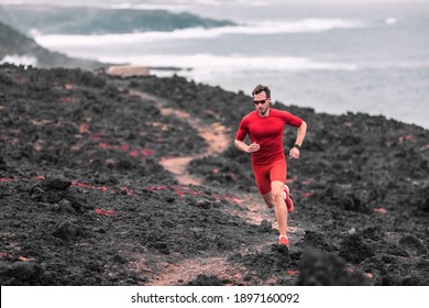 Outdoor Sport Athlete Man Trail Running In Volcanic Extreme Terrain Landscape. Long Distance Ultra Run Runner Man Training For Competition In Nature Mountain Cliff By The Sea.