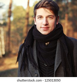 Outdoor Spring Portrait Of Young Handsome Man In Park. Boy Dressed In Woolen Coat, Sweater And Scarf.