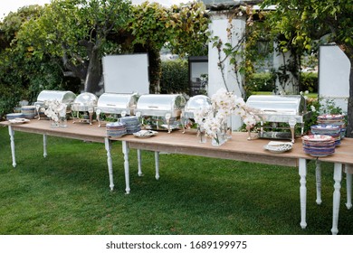 Outdoor Spring Or Summer Casual Garden Party Set Up For Lunch Dinner With Long Table, Flowers