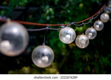 Outdoor String Lights Hanging On The Line In The Garden