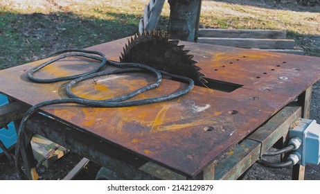 Outdoor Table Saw With Rusty Blade And Metal Top Plate Powered By High Power Electric Engine