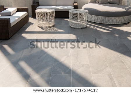 Outdoor terrace area with grey floor tile with sitting area
