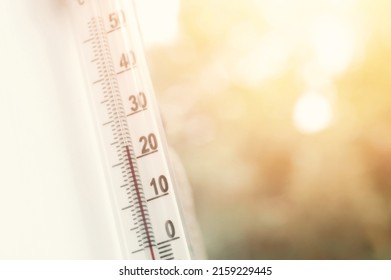 Outdoor thermometer outside the window of the house is close-up. Thermometer scale with plus air temperature. A device for determining the air temperature outside the house. Selective focus