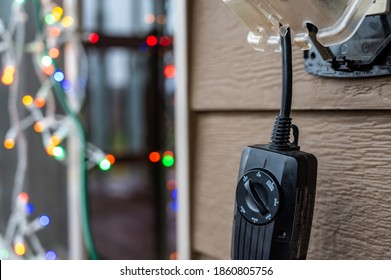 Outdoor Timer And GCFI Outlet With Cover. Blurred Christmas Lights In Background.