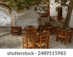 Outdoor, traditional tavern with wooden chairs and tables in Apeiranthos village, Naxos island